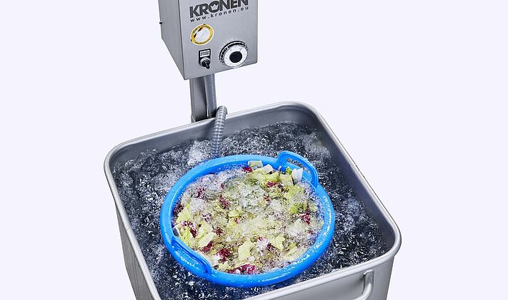 Laveur à soufflante par lot DS1000 mobile de KRONEN pour le lavage bouillonnant, le trempage et le traitement hygiénique, ici avec de la salade composée coupée