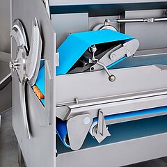 Der Niederhalter und die Produktführung der Bandschneidemaschine GS 20 von KRONEN garantieren perfekte Qualität und schonenden Produktaustrag.