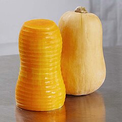 Pelage net et sans stries des courges avec l’éplucheuse à ananas et à melons AMS 220 de KRONEN grâce au système innovant de pelage à couteaux guidé.